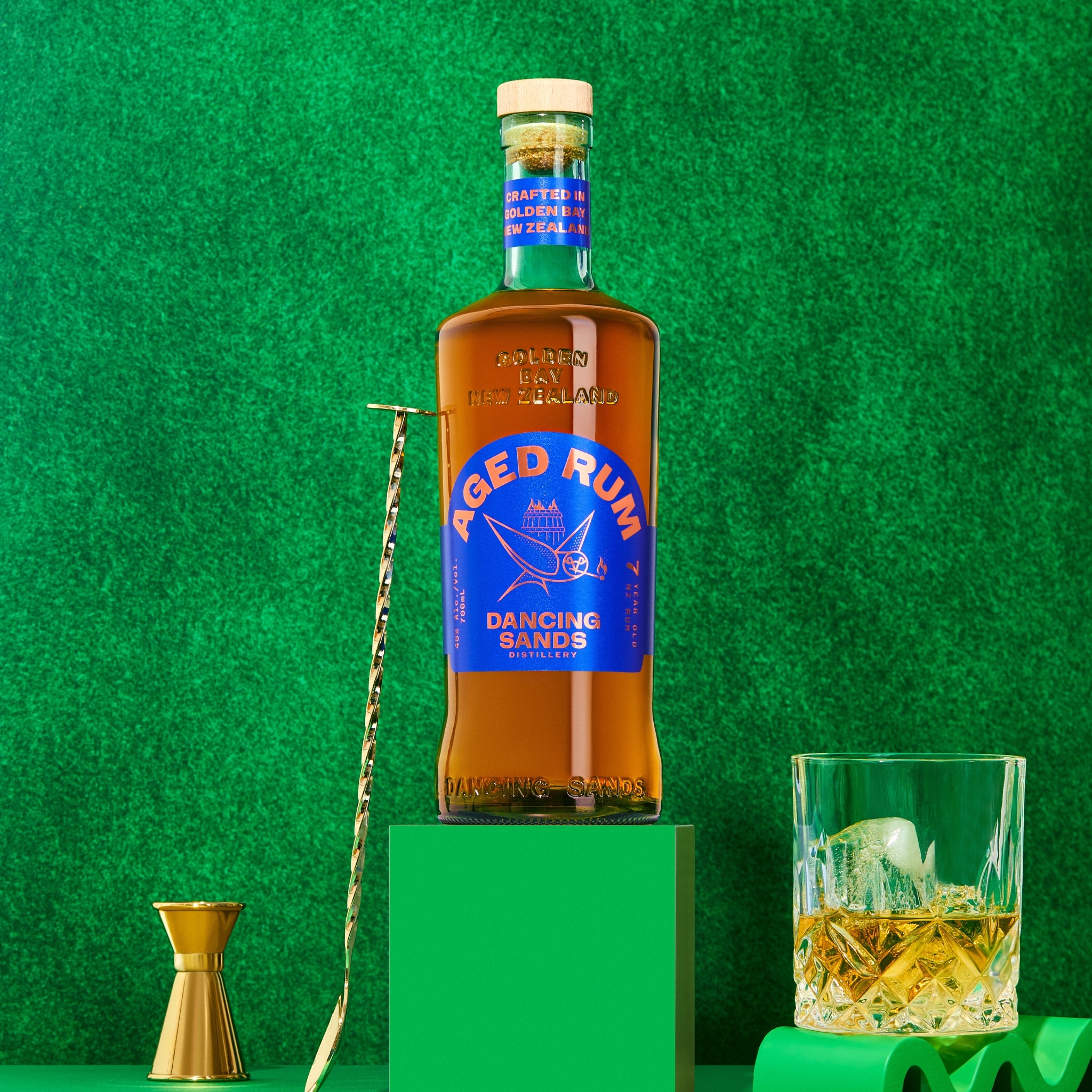 Bottle of Aged Rum with a blue label on a green background