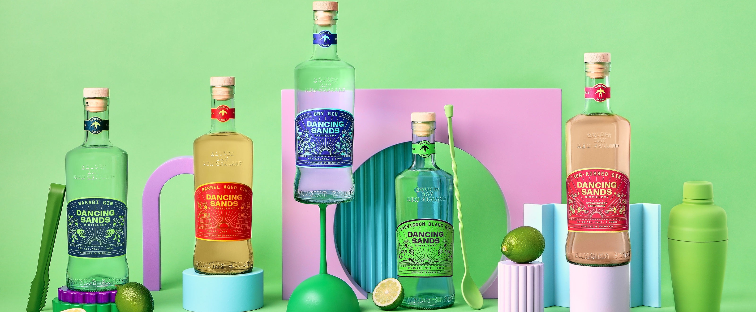 Collection of colorful Dancing Sands bottles with labels on a vibrant green background